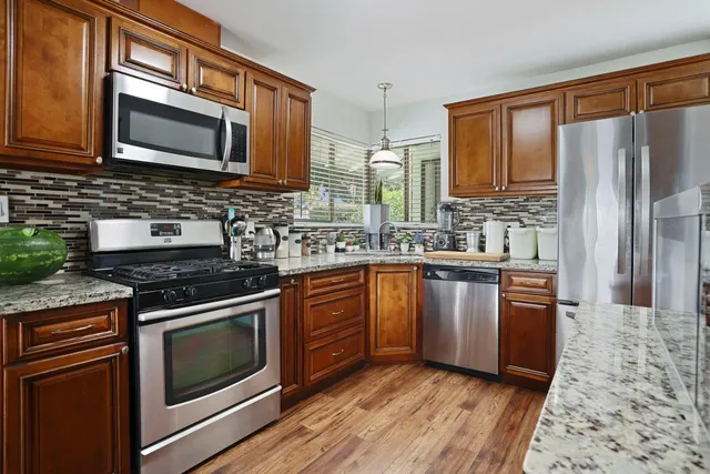 a kitchen with stainless steel appliances granite countertop a stove microwave sink and refrigerator