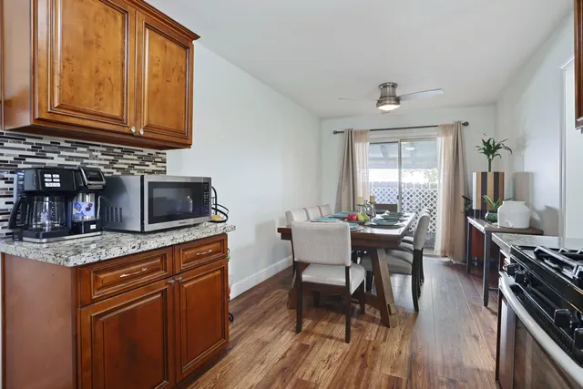 a kitchen with stainless steel appliances granite countertop a stove top oven a sink dishwasher and cabinets with wooden floor