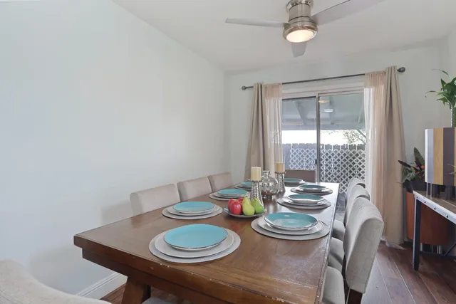 a dining room with furniture a large window and wooden floor