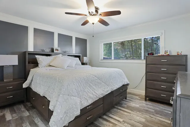 a bedroom with a bed and a ceiling fan
