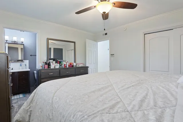 a bedroom with a bed and a mirror on the dresser