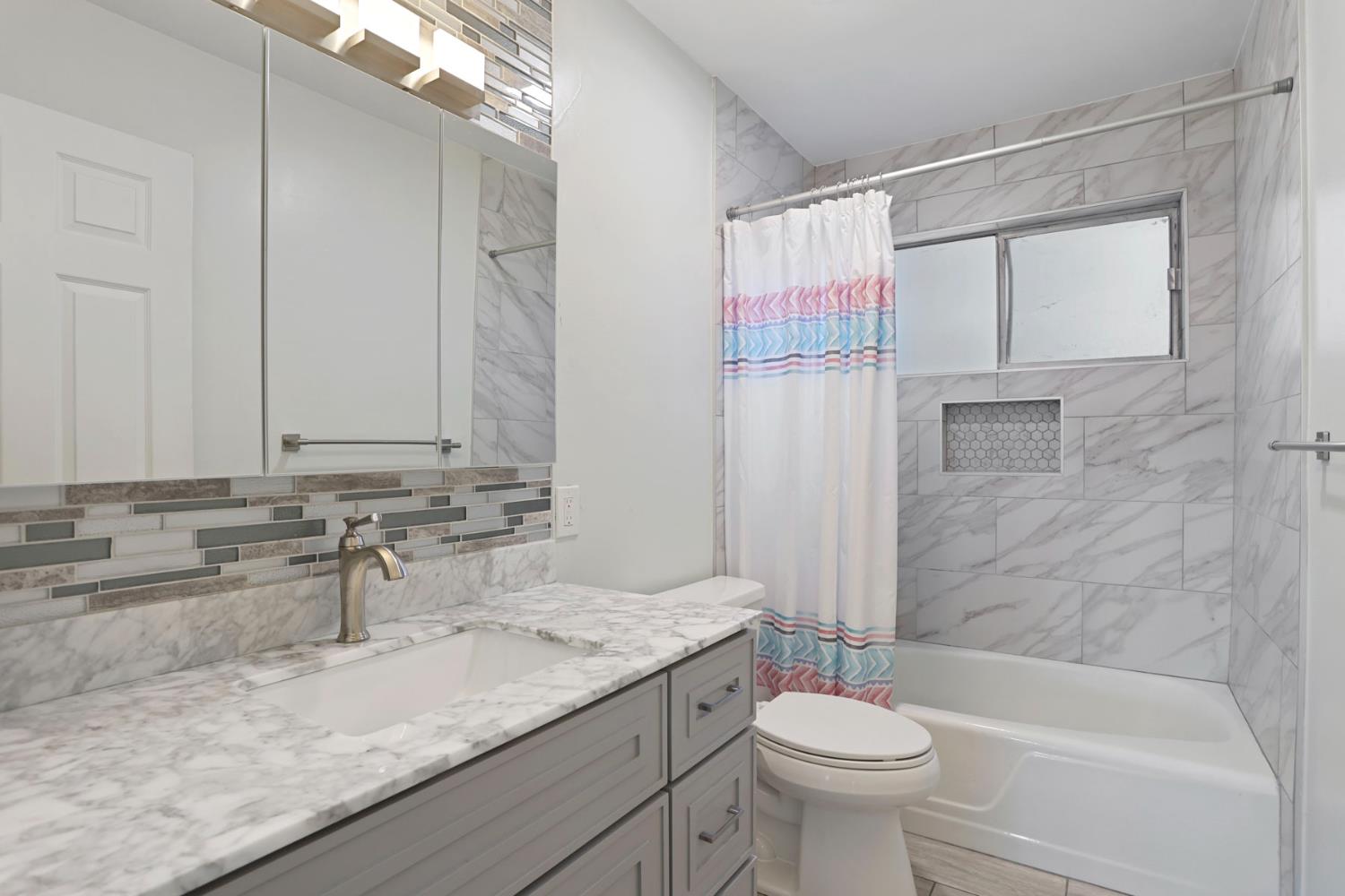 518 West Lincoln Road Stockton, CA 95207 - Photo 10 of 38 a bathroom with a granite countertop sink a toilet and shower