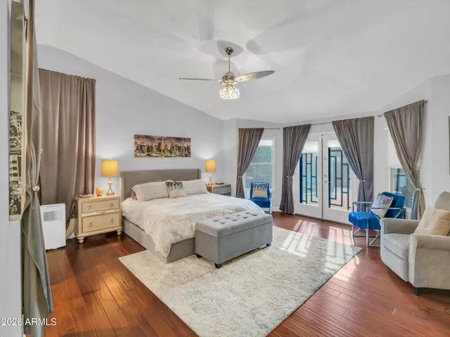 a spacious bedroom with a large bed and a chandelier