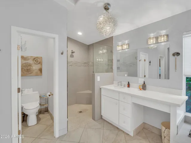 a bathroom with a double vanity sink toilet and shower