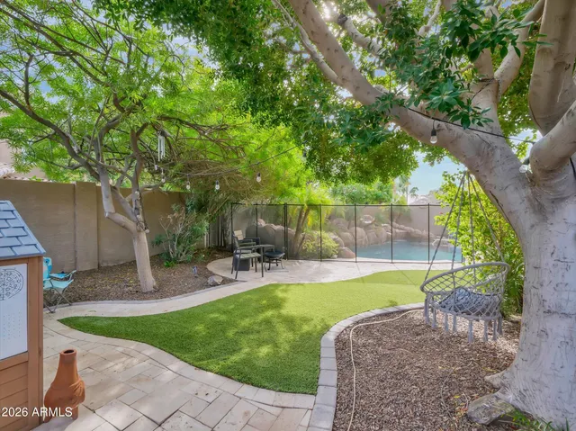 a view of a patio with table and chairs potted plants and large tree