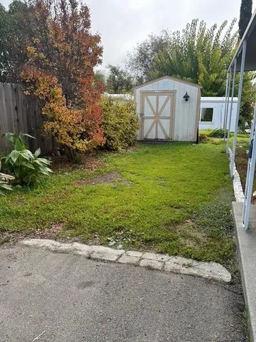 a view of a white house with a big yard and large trees