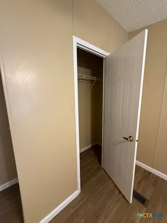 an empty room with wooden floor and closet