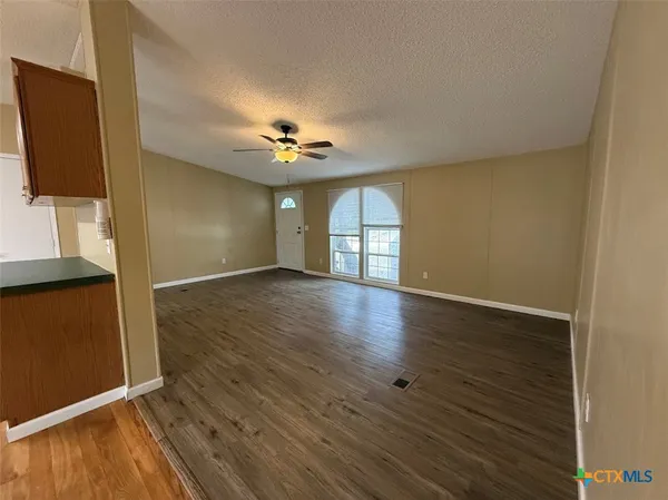 an empty room with wooden floor and mirror