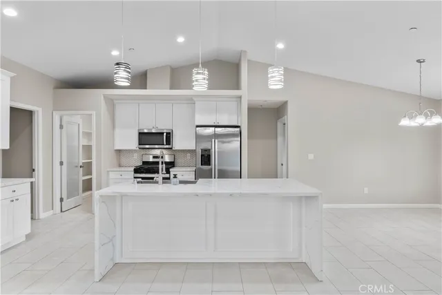 a large kitchen with kitchen island a sink stainless steel appliances and cabinets
