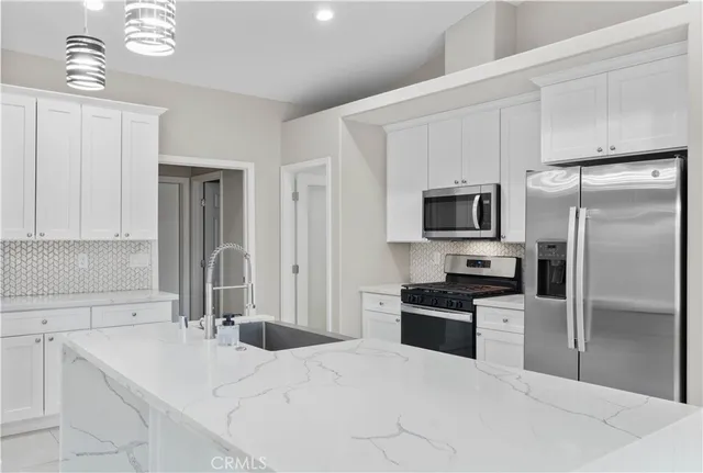 a kitchen with stainless steel appliances a refrigerator sink and microwave