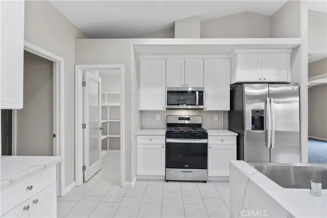 a kitchen with stainless steel appliances kitchen island granite countertop a refrigerator and a sink