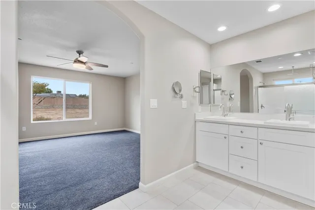 a spacious bathroom with a double vanity sink a window and a mirror