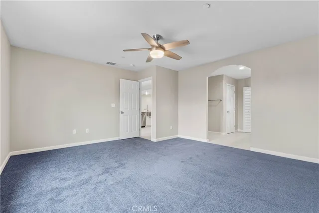 a view of an empty room with a ceiling fan