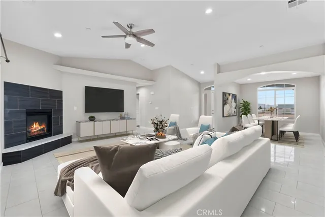 a living room with furniture a flat screen tv and a fireplace