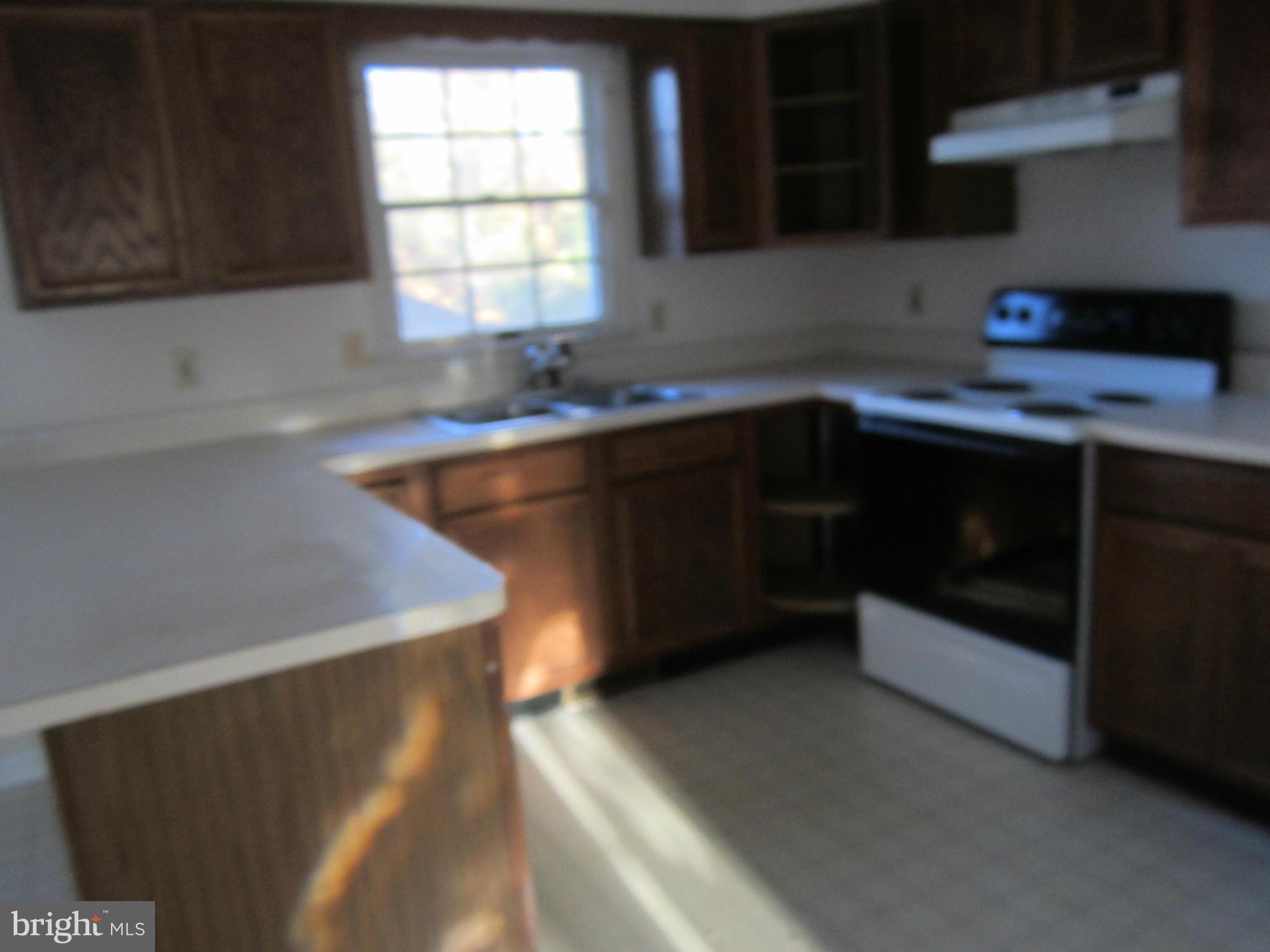 146 Calvert Towne Road Prince Frederick, MD 20678 - Photo 3 of 13 a kitchen with a sink a window and cabinets