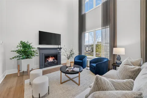 a living room with furniture a fireplace and a large window