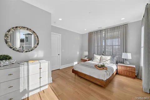 a bedroom with a bed a mirror and a potted plant