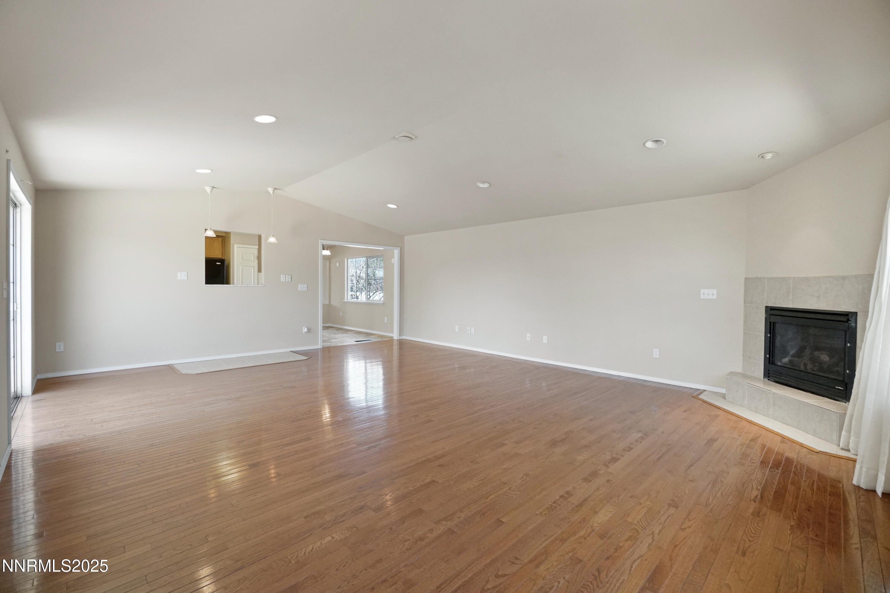 546 Yellow Jacket Road Dayton, NV 89403 - Photo 10 of 25 an empty room with wooden floor and fireplace