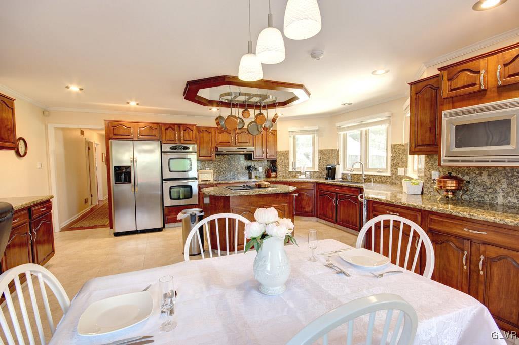 2270 Bishop Road Allentown, PA 18103 - Photo 13 of 33 a kitchen with stainless steel appliances granite countertop a kitchen island a stove a dining table and chairs with wooden floor