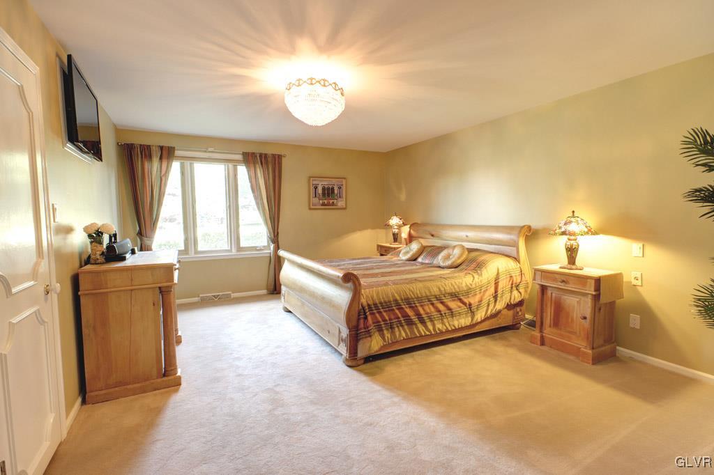 2270 Bishop Road Allentown, PA 18103 - Photo 14 of 33 a spacious bedroom with a bed and a chandelier