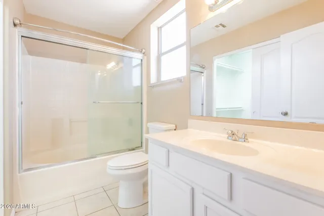 an empty room with closet and a chandelier fan