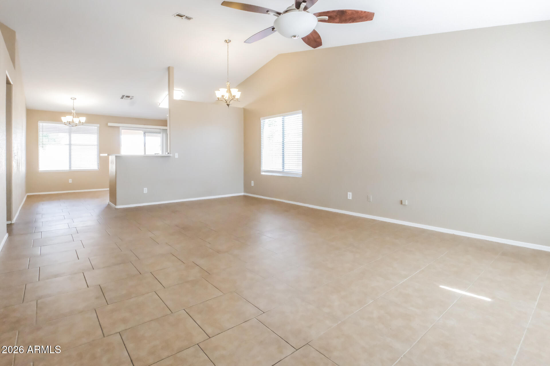 1108 West 13th Avenue Apache Junction, AZ 85120 - Photo 4 of 21 an empty room with a chandelier fan and windows