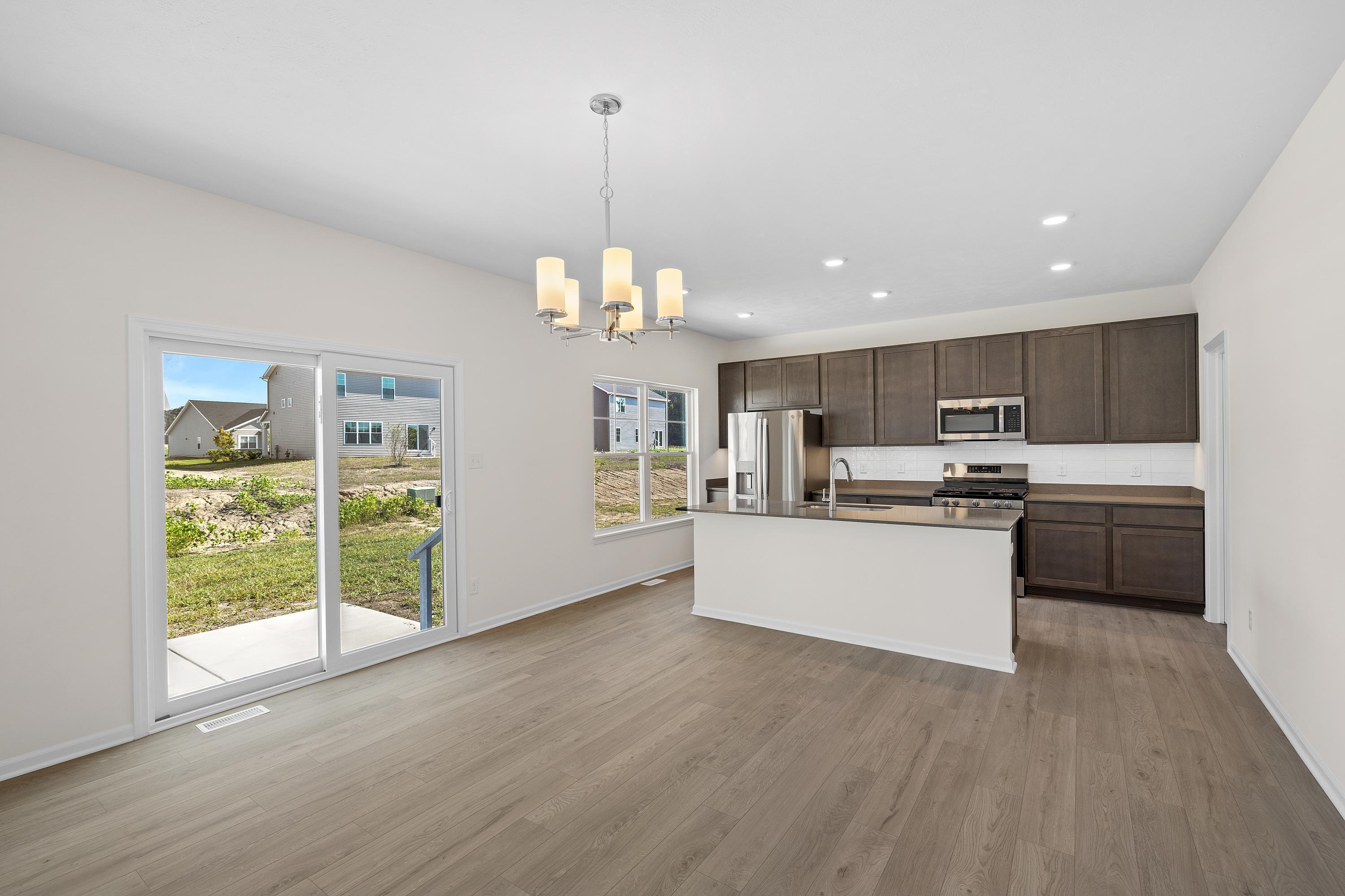 3758 Wild Grove Way Valparaiso, IN 46385 - Photo 5 of 19 a open kitchen with kitchen island white cabinets and stainless steel appliances