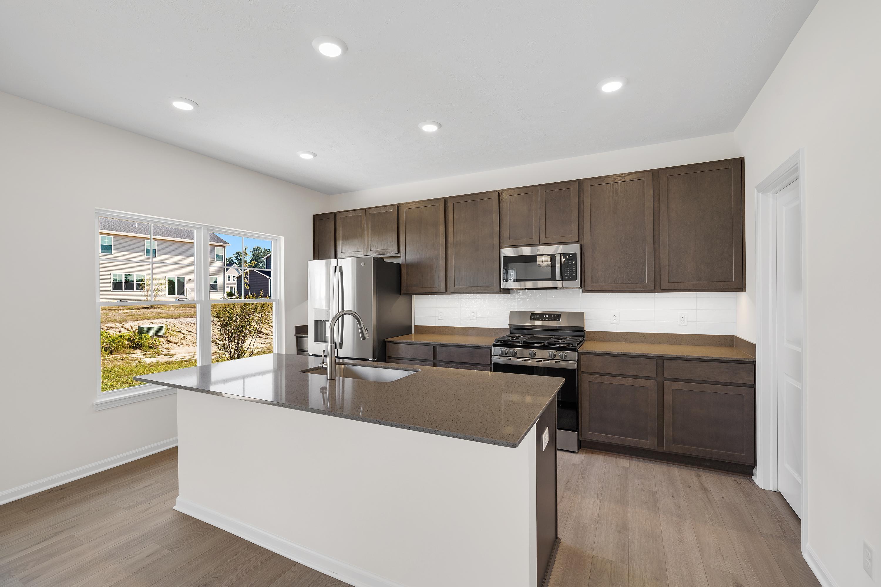 3758 Wild Grove Way Valparaiso, IN 46385 - Photo 6 of 19 a kitchen with stainless steel appliances granite countertop a refrigerator stove microwave and sink