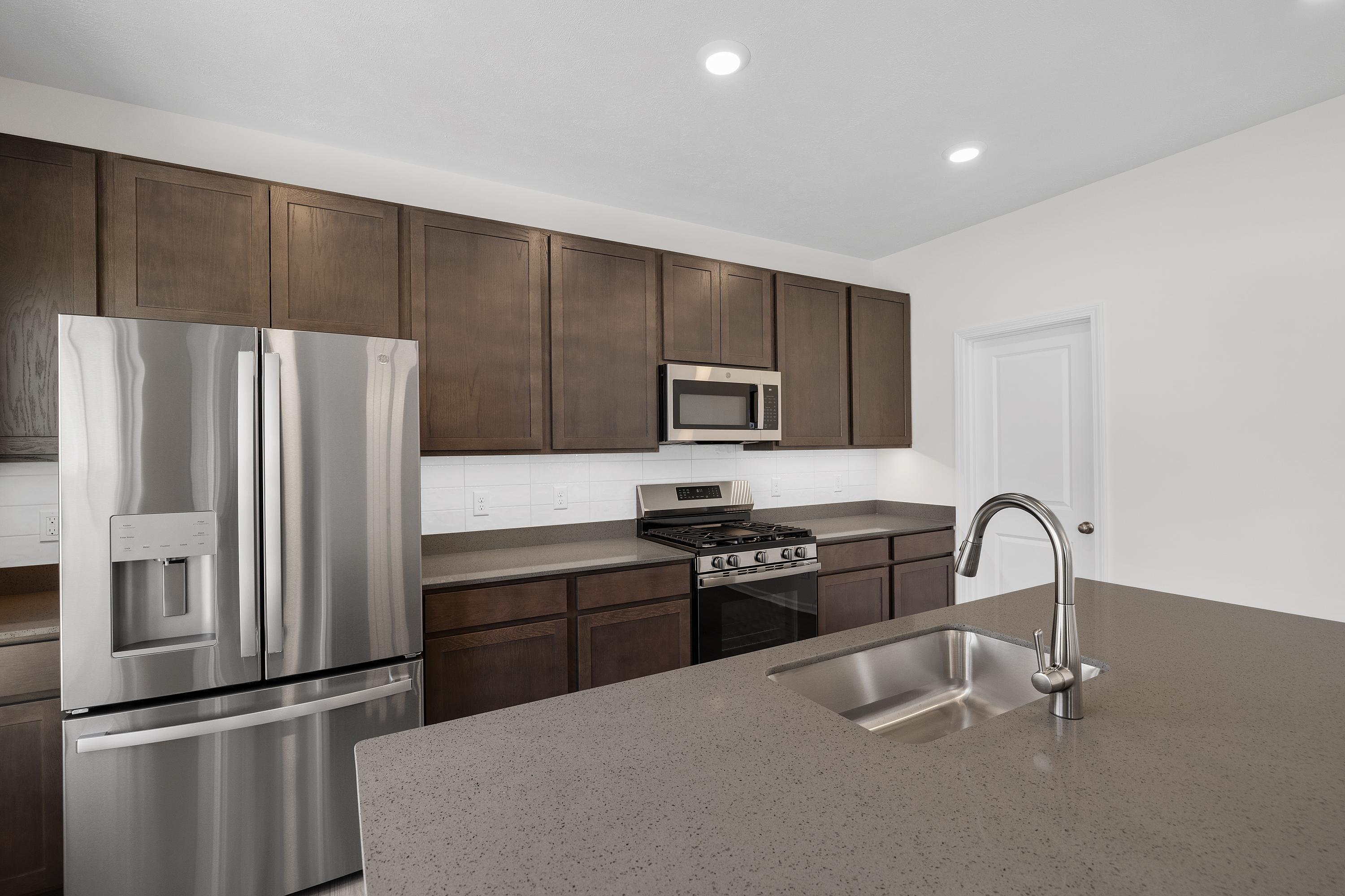3758 Wild Grove Way Valparaiso, IN 46385 - Photo 8 of 19 a kitchen with granite countertop a refrigerator stove and sink