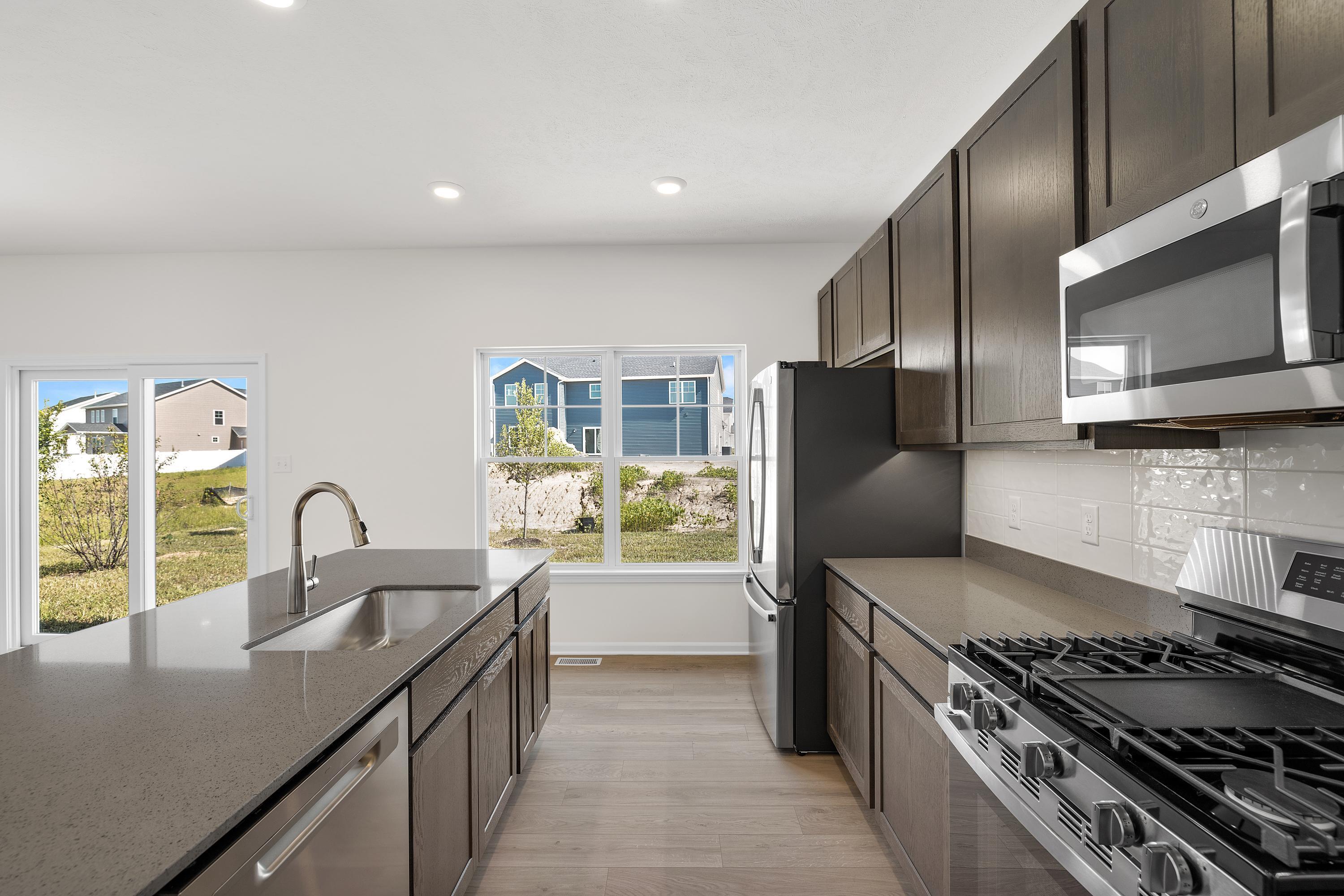 3758 Wild Grove Way Valparaiso, IN 46385 - Photo 9 of 19 a kitchen with granite countertop a stove and a refrigerator