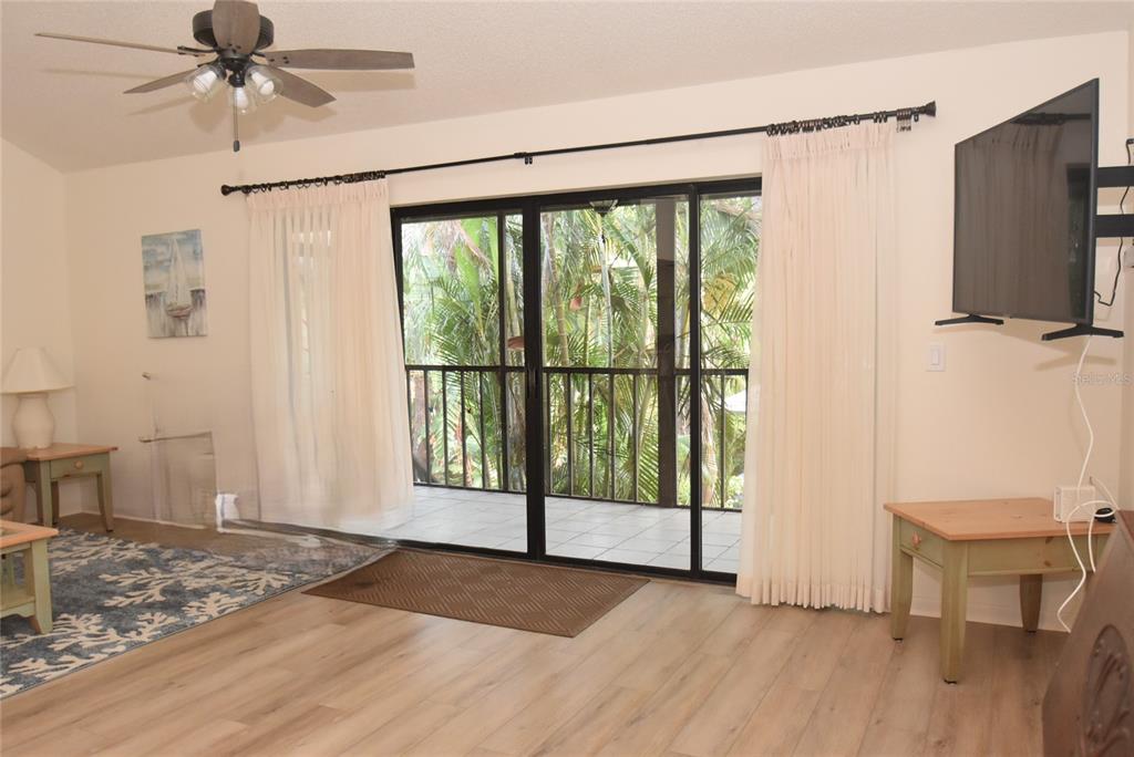 1712 Glenhouse Drive, Unit GL418 Sarasota, FL 34231 - Photo 29 of 37 a view of a room with a flat screen tv and a floor to ceiling window