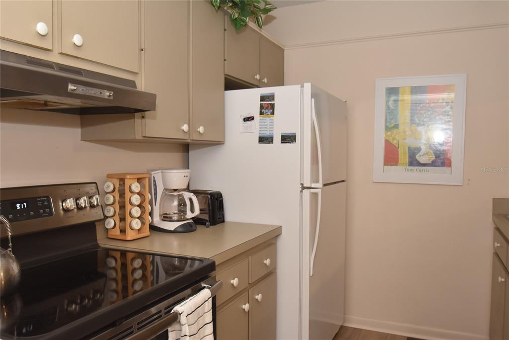 1712 Glenhouse Drive, Unit GL418 Sarasota, FL 34231 - Photo 31 of 37 a kitchen with a refrigerator and a stove top oven