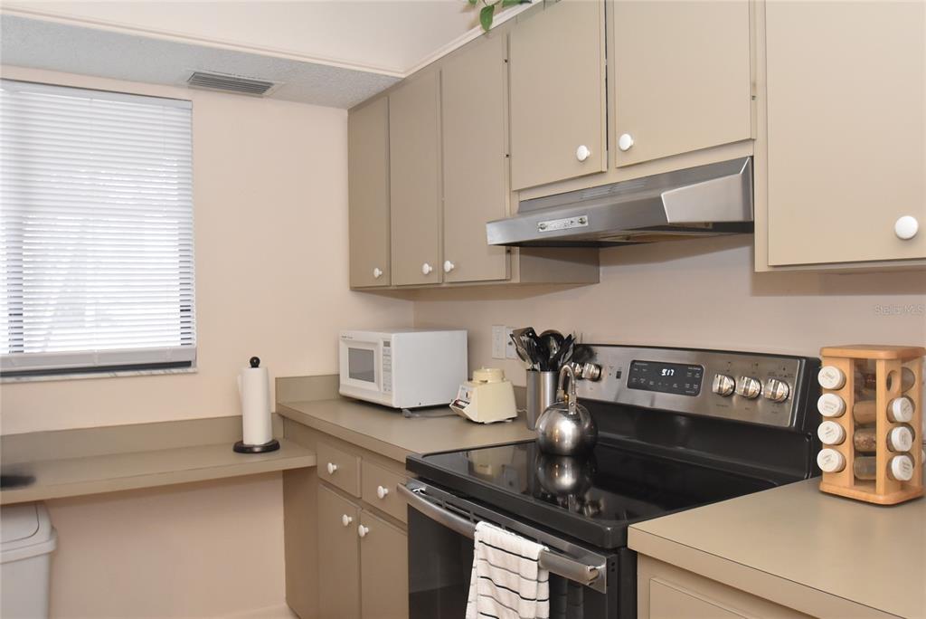 1712 Glenhouse Drive, Unit GL418 Sarasota, FL 34231 - Photo 32 of 37 a kitchen with granite countertop a sink a stove and cabinets