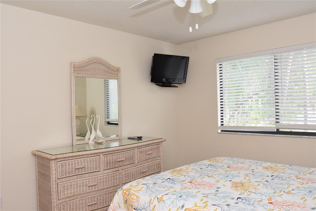 1712 Glenhouse Drive, Unit GL418 Sarasota, FL 34231 - Photo 34 of 37 a bedroom with a large bed and a flat screen tv