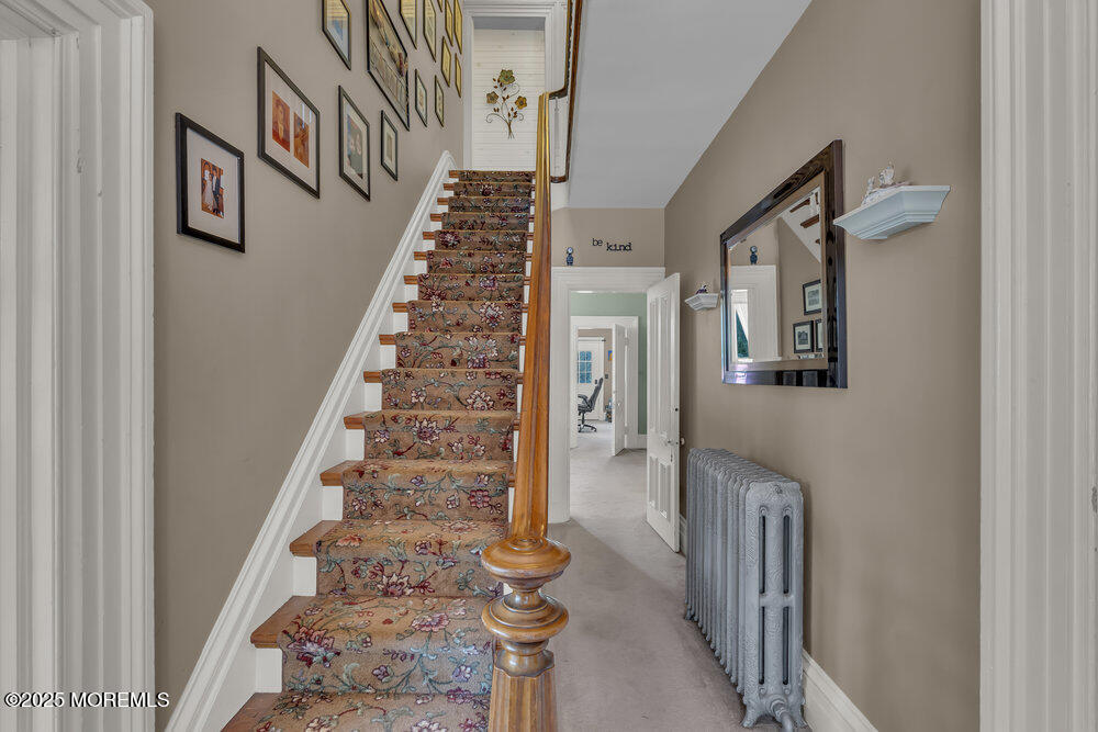 75 Elizabeth Street Keyport, NJ 07735 - Photo 23 of 61 a view of staircase with lots of frames on wall and a potted plant