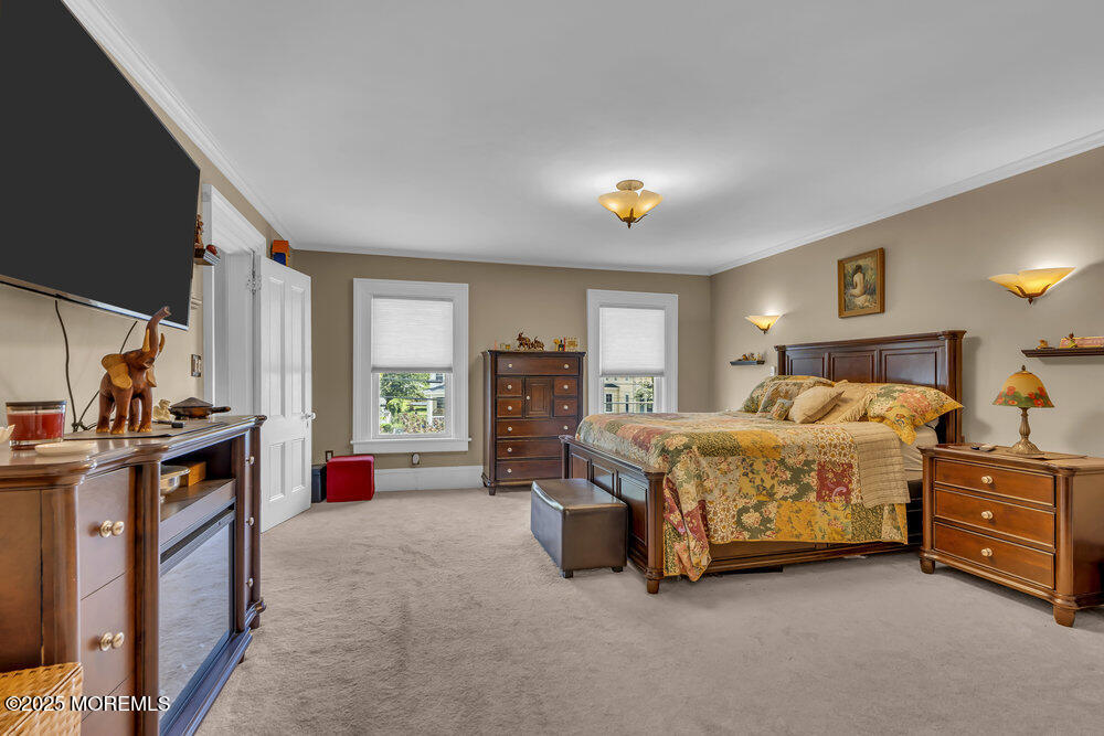 75 Elizabeth Street Keyport, NJ 07735 - Photo 26 of 61 a spacious bedroom with a bed and a chandelier