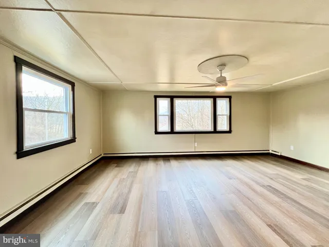 a view of a room with wooden floor and window