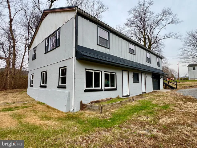a yellow house with trees in front of it
