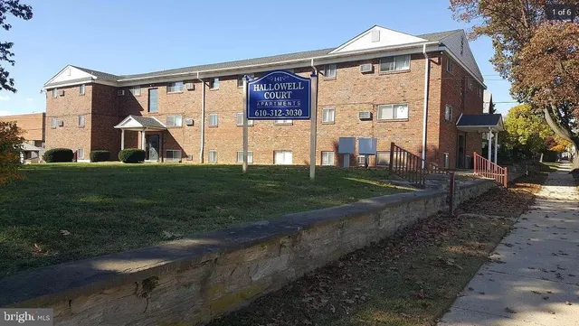 a view of a big house with a big yard and large trees