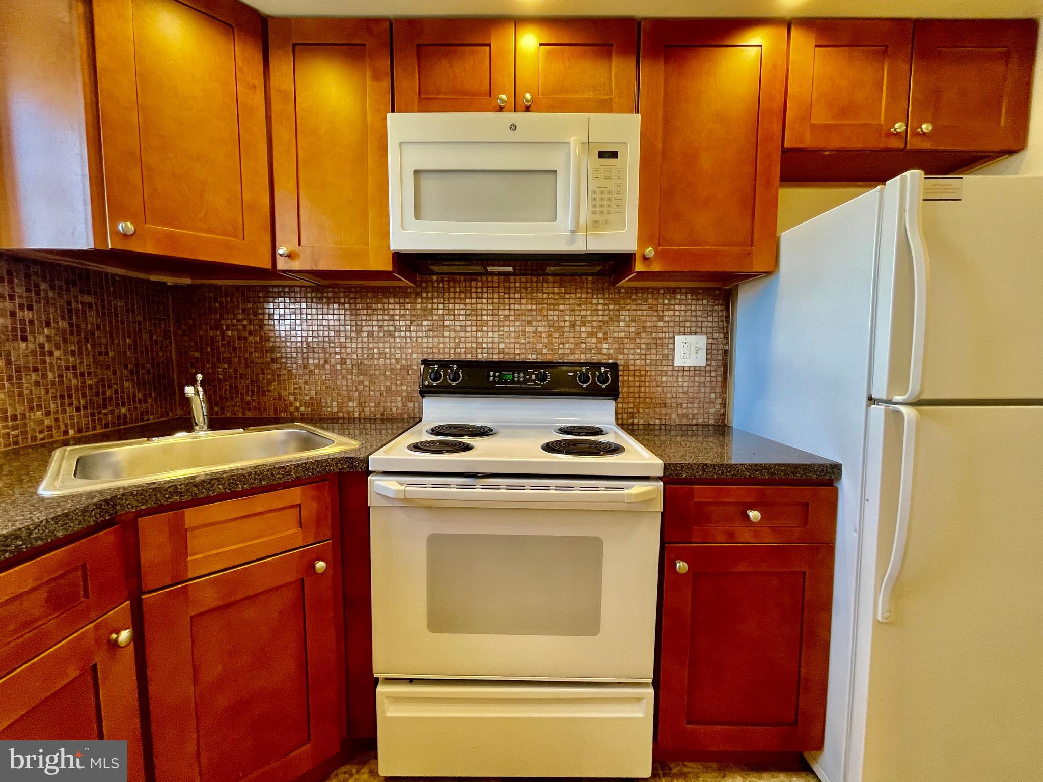 141 East 4th Avenue, Unit A1 Conshohocken, PA 19428 - Photo 3 of 10 a kitchen with stainless steel appliances granite countertop a stove a microwave and a refrigerator