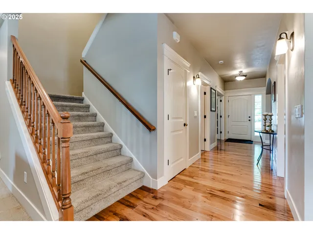 a view of a hallway with wooden floor and staircase