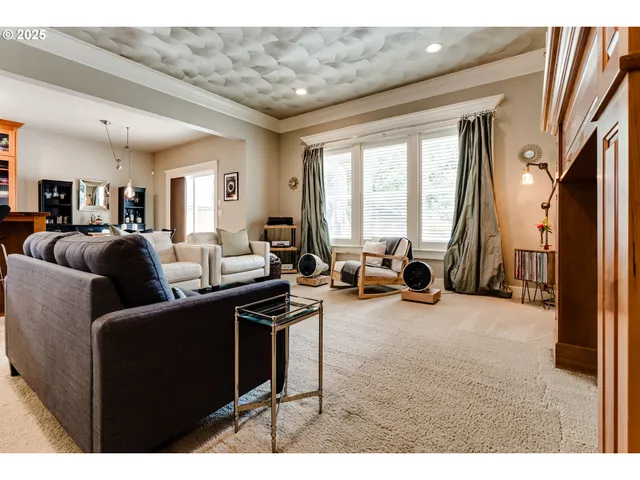 a living room with furniture a large window and a chandelier