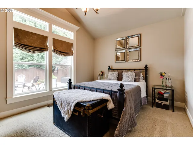 a bedroom with a bed and a large window