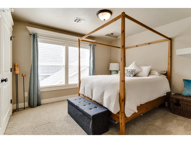 a bedroom with a bed window and a night stand