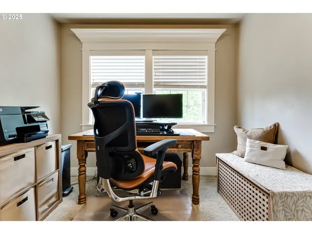 a view of a workspace with furniture and a window