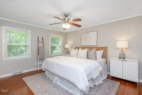 a bedroom with a large bed chandelier and a window