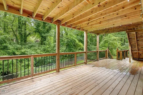a view of balcony with wooden floor and fence