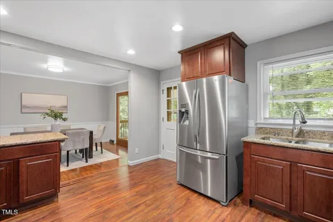 a kitchen with stainless steel appliances granite countertop a refrigerator microwave and wooden floor