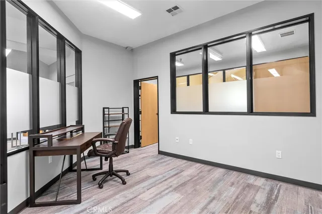a view of a workspace with furniture and wooden floor