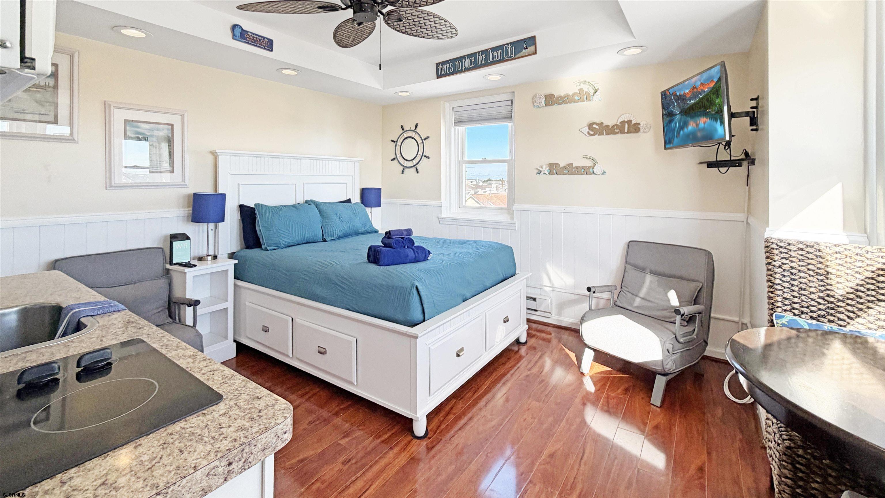 807 East 8th Street, Unit 511 Ocean City, NJ 08226 - Photo 3 of 12 a bedroom with a bed and wooden floor